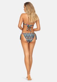 Zestaw bikini z topem bandeau i niskim dołem z akcentami wiązanymi. Wykonany z elastycznego materiału, ozdobiony kolorowym wzorem fal.