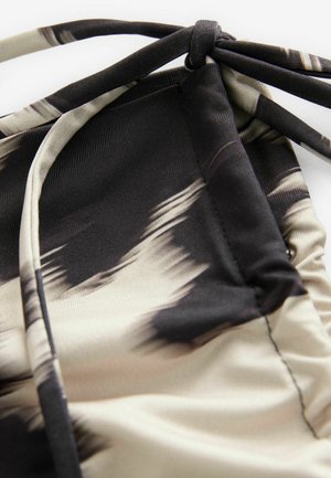 Lightweight swimwear fabric with an abstract beige and black pattern, featuring gathered texture and adjustable ties for fit.