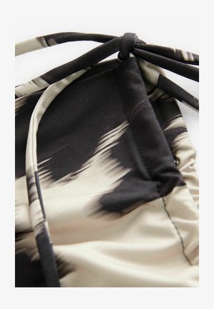 Leichtes Schwimmstoffgewebe mit einem abstrakten beige-schwarzen Muster, das eine geraffte Textur und verstellbare Bänder für die Passform bietet.