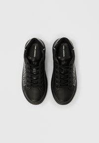 Zapatillas deportivas de cuero negro con un acabado suave, que cuentan con un panel lateral texturizado con pedrería y cordones a juego.