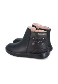 Botas negras de cuero hasta el tobillo con diseño de cara de gato, interior rosa y cierre con cremallera. Suela ligera y nombre de la marca en la parte trasera.
