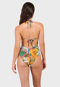 Enstycke baddräkt med färgglada abstrakta mönster, justerbara knytband och öppen ryggdesign. Materialet verkar slätt och elastiskt.