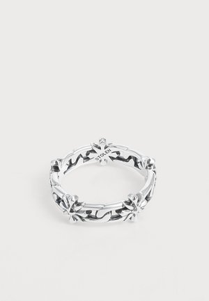 Bague en chaîne argent avec motifs croix décoratifs et le mot "STOLEN" gravé à l’intérieur de l’anneau sur un fond blanc uni.