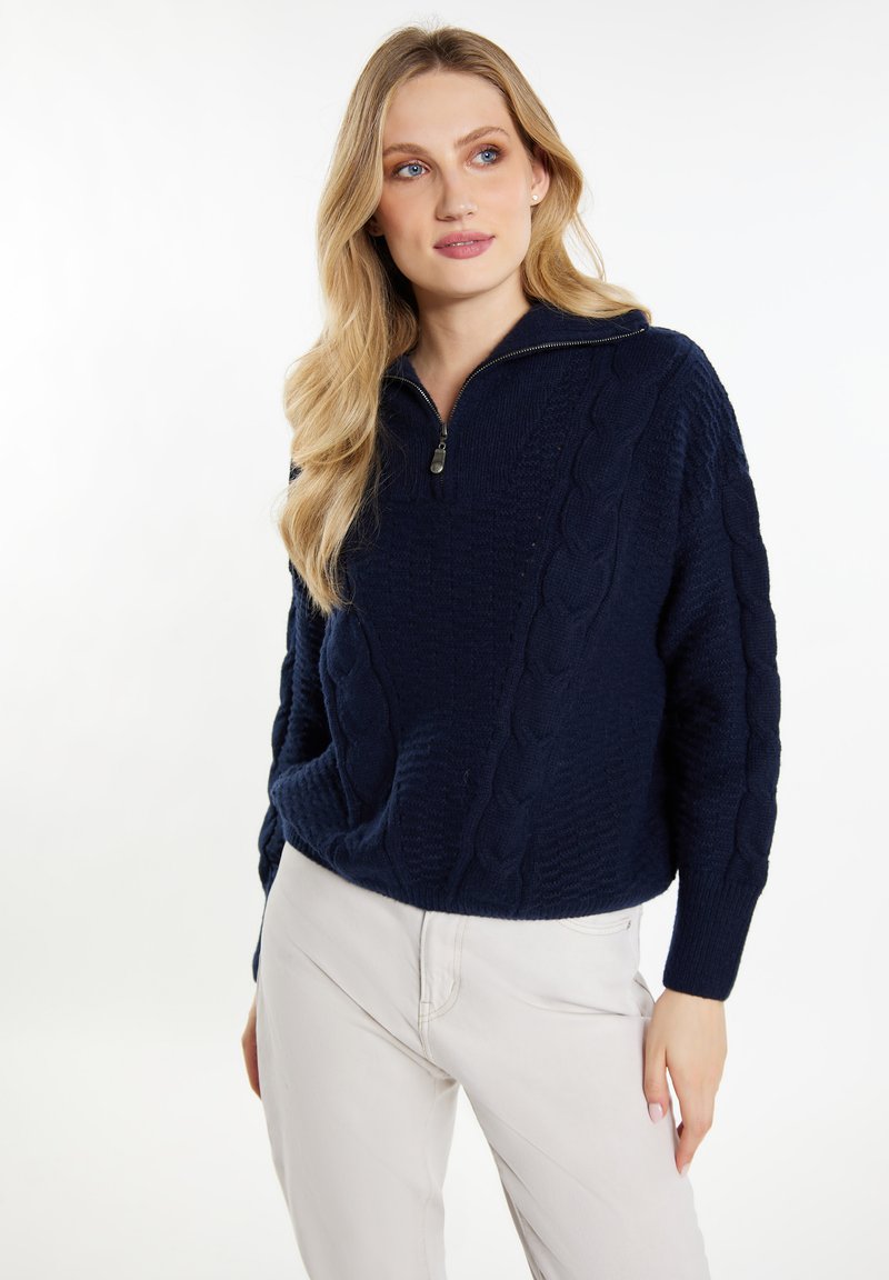 Pulover bleumarin cu guler zip, cu design tricotat în cablu și manșete cu nervuri. Fabricat din material texturat, având o croială largă și buzunare laterale.