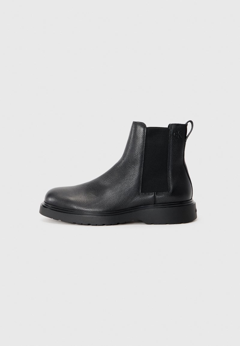 Black leather chelsea boots featuring a textured finish, elastic side panels, and a sturdy rubber sole. Subtle branding on the heel.