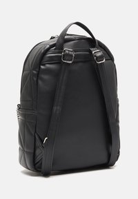 Czarny skórzany plecak z pikowanym wzorem, regulowanymi paskami, górnym uchwytem i srebrnym zamkiem błyskawicznym. Gładka faktura o usztywnionym kształcie.