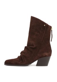 Bottine en suède marron avec tige froncée, bout pointu, petit talon épais et zip à l'arrière avec tirette.