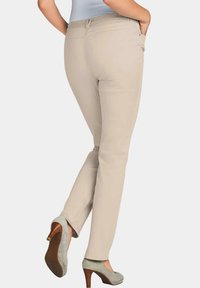 Beige enkellange broek gemaakt van zachte stof met een gladde textuur, voorzien van zijzakken en een lichte stretch voor comfort.