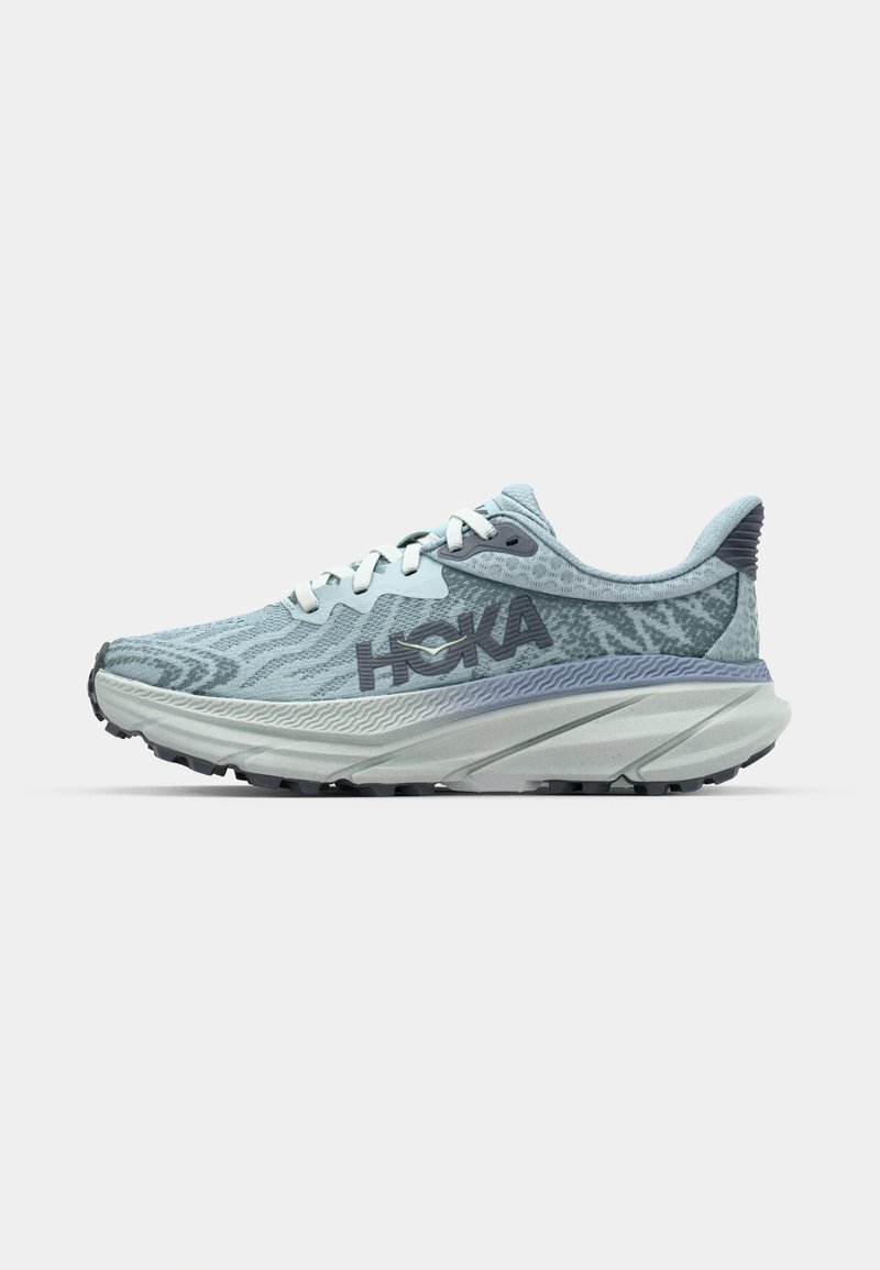 Zapatilla de running azul claro con parte superior texturizada, logotipo prominente de Hoka, entresuela gruesa y suela rugosa para tracción.