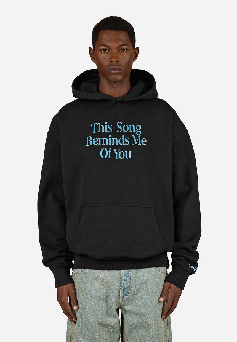 Čierna mikina s kapucňou vyrobená z bavlneného zmesi, na prednej strane s modrým textom "Táto pieseň mi pripomína teba". Obsahuje klokaní vrecko.