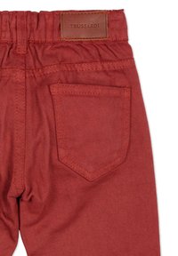 Rode denim broek met elastische tailleband, voorzien van een achterzak en een lederen label met de tekst "TRUSSARDI." Soepele textuur en een op maat gemaakte ontwerp.