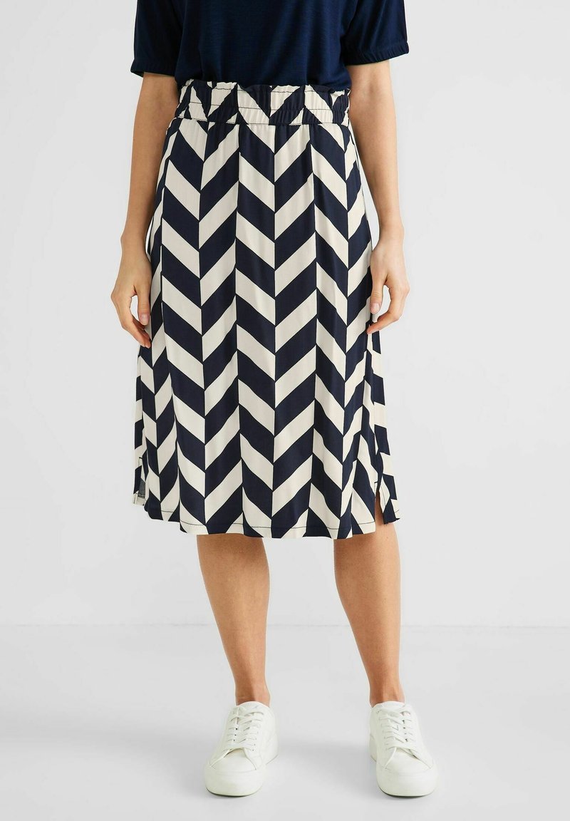 Sini ja kermankeltaisen viuhkamaisen kuosin hame, jossa on joustava vyötärö, polvimittainen, kevyt kangas, ja sivuaukot liikkumisen helpottamiseksi.