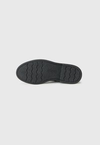 Zwarte rubberen schoenzool met gestructureerd golvend patroon en gemoldere branding; afgeronde vorm met een lichte boog voor comfort en grip.