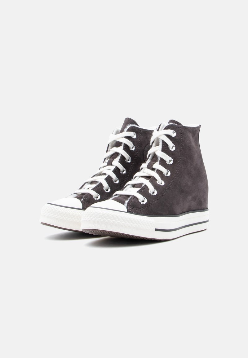 Grå ruskind høje sneakers med hvide snørebånd, gummiforstærket tåkap og tekstureret sål. Har en hvid mellemsål med sorte striber.