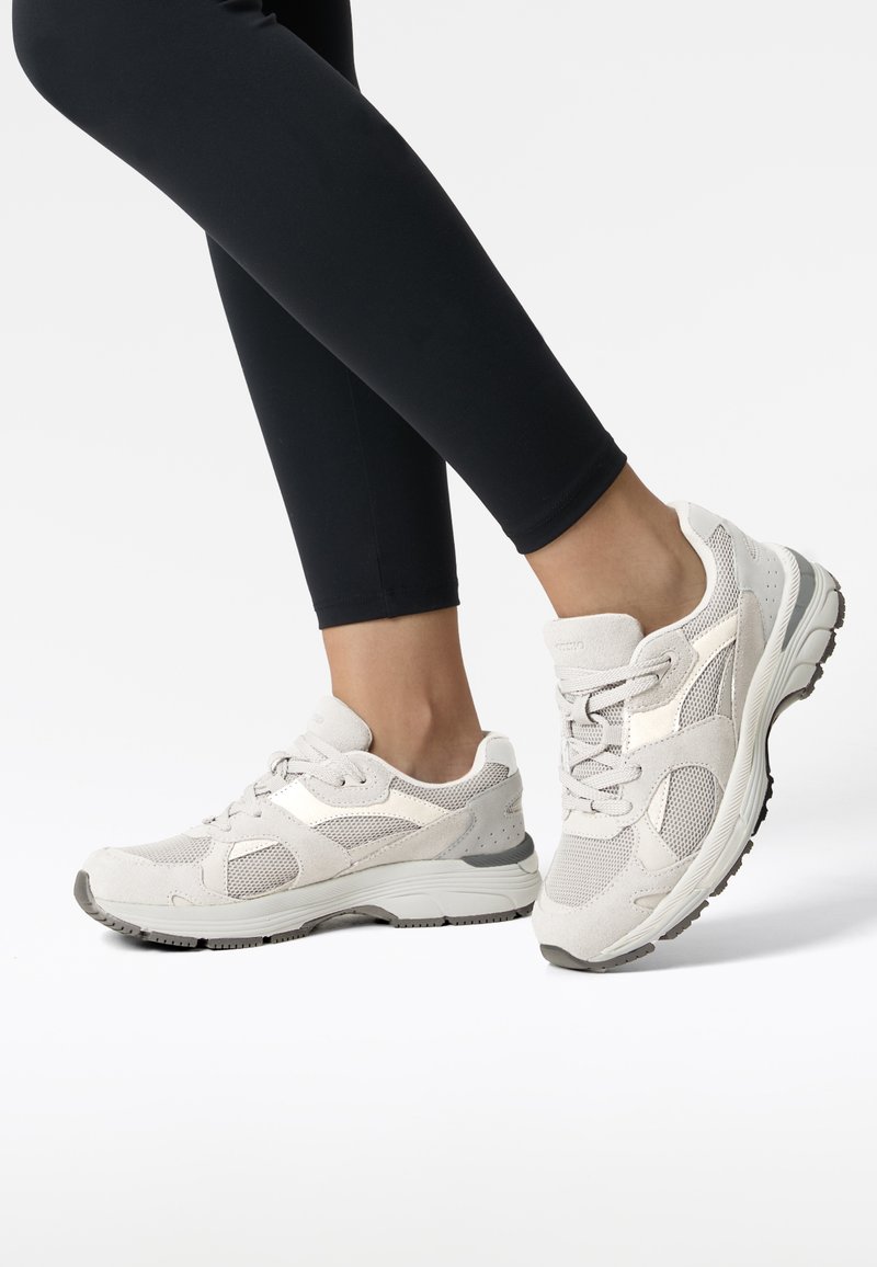 Jasnoszare sneakersy z siateczkowych i zamszowych materiałów, z wyściełaną podeszwą, sznurówkami i subtelnymi akcentami designu.