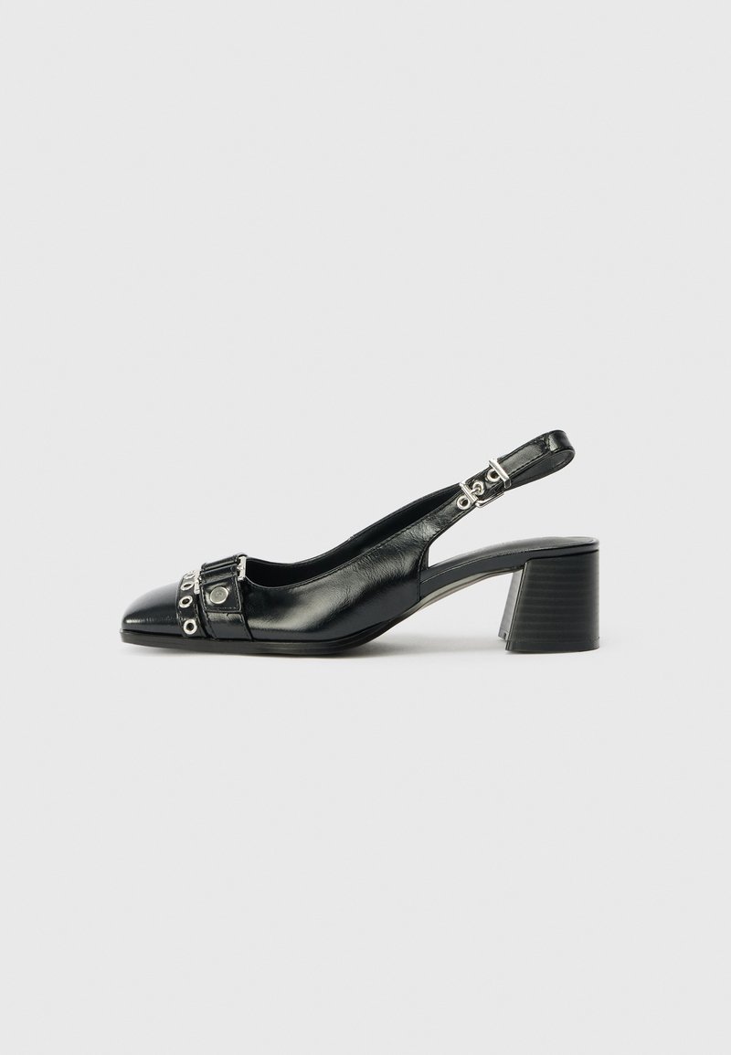 Black leather slingback heel with a pointed toe, textured strap featuring circular metallic accents, and a stacked block heel.