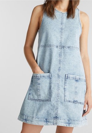 Lichtblauwe denim mouwloze jurk met een ronde halslijn, twee grote voorkepers, gestikte details en een licht uitlopende zoom.