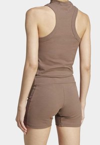 Brown ribbed athletic tank top and shorts set with a fitted design, featuring a high neckline and sleeveless cut for enhanced mobility.