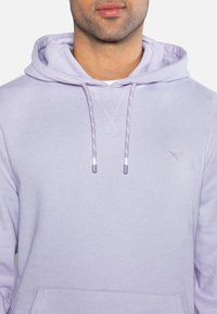 Felpa viola chiaro realizzata in tessuto morbido, con cappuccio regolabile, tasca a marsupio e un piccolo logo ricamato sul petto.
