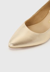 Scarpa con punta a punta in pelle metallizzata oro, caratterizzata da una texture liscia e da un collo basso, adatta per occasioni formali o semi-formali.