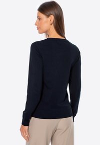 Granatowy sweter dzianinowy z długimi rękawami, okrągłym dekoltem oraz ściągaczami przy mankietach i dolnej krawędzi. Gładka struktura z dopasowanym krojem.