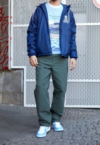 Marinblå vindjacka med vita detaljer, ljusblå sweatshirt med tryck, olivgröna byxor och vita sneakers med ljusblå detaljer.