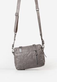 Borsa a tracolla in pelle grigia con tracolla regolabile, tasca con zip frontale e chiusura a patta su sfondo bianco.