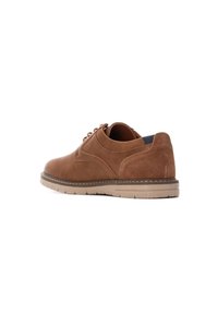 Zapatos de cuero y ante marrón con puntera redondeada, parte superior texturizada, diseño de cordones y suela de goma ligera; perfil bajo con costuras sutiles.