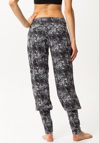 Svart och vitmönstrade lösa byxor med tapered ankeldesign och mjuk textur. Har en elastisk midja för komfort.