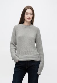 Helehall kudumismustriga kampsun, millel on tekstuuriga muster ja soonikuga kaelus. Alläär ja pikad varrukad on jämedamast kootud.