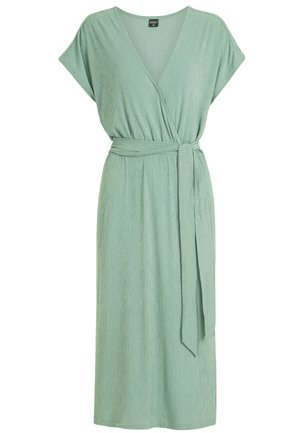 Zielona sukienka w stylu kopertowym z głębokim dekoltem w kształcie litery V, krótkimi rękawami i regulowanym paskiem. Teksturowany materiał ma delikatny prążkowany wzór.