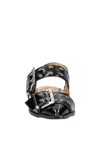 Zwarte gepatenteerde leren slidesandalen met twee brede banden, zilveren sluitingen en cirkelvormige uitsparingen. Open teen ontwerp met een glanzende afwerking.