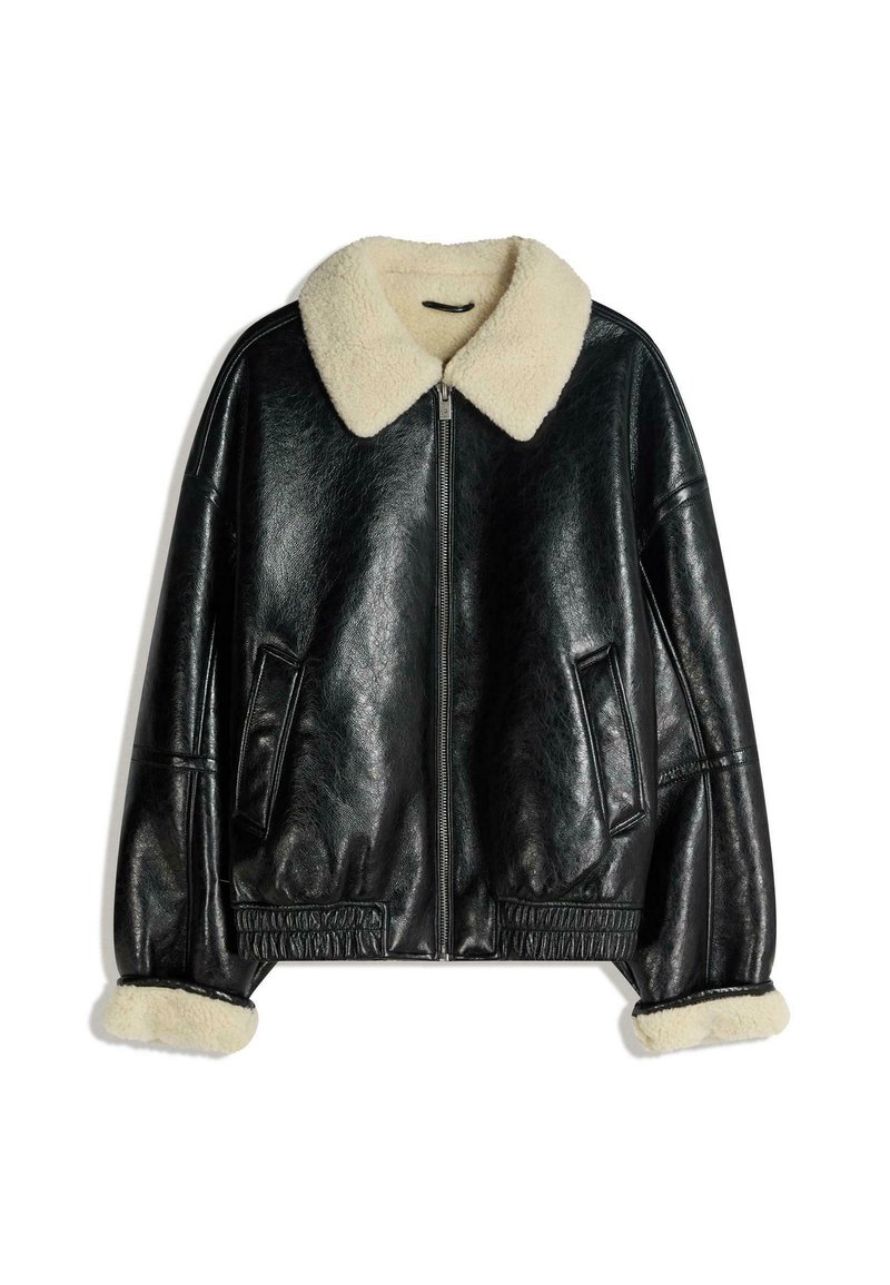 Crna kožna jakna s kremastim umjetnim ovčjim krznom na ovratniku i manžetama, koja ima zatvaranje na patentni zatvarač i bočne džepove, s teksturiranim završetkom.