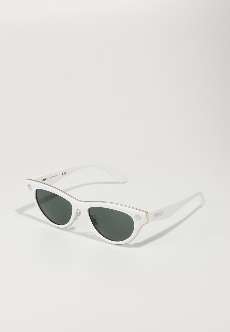 Valkoiset kissankäppärisilmälasit tummilla linsseillä, kultaisia yksityiskohtia kehykset, ja logopainatus sivulla. Sileä muovimateriaali.