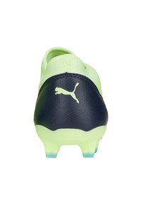 Scarpa da calcio verde brillante con tallone testurizzato blu navy, motivo esagonale, suola traslucida e logo Puma a contrasto sul retro.