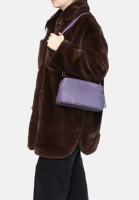 Borsa a mano in pelle viola con forma rettangolare e chiusura con zip, dotata di hardware argentato e di una tracolla corta e regolabile.