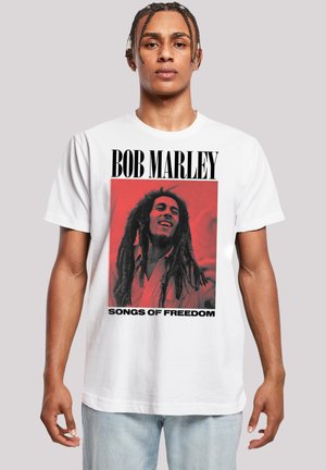 White cotton t-shirt featuring a red graphic print of Bob Marley with black text reading "BOB MARLEY" and "SONGS OF FREEDOM" below.