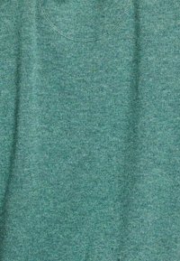 Teal gebreide stof met een fijne textuur en een ronde halslijn en een zakdetail. De weving is consistent door het materiaal.