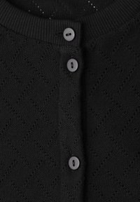 Cardigan noir en maille avec col côtelé et trois boutons noirs ronds, présentant un motif discret en losange sur le tissu.