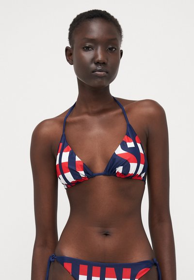 Top de bikini albastru marin, cu cupe triunghiulare, model grafic roșu și alb, cu legături la gât și margini pliate pentru un fit ajustabil.