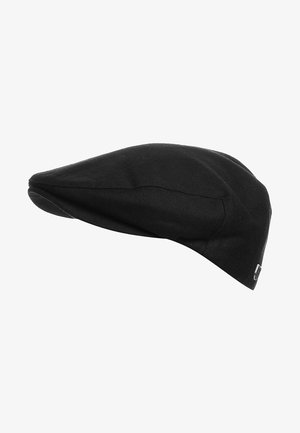 Casquette plate noire avec une partie supérieure arrondie et une petite visière, présentant un motif discret en chevrons et un petit logo métallique sur le côté.