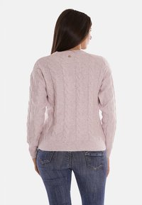 Maglione a coste di colore rosa chiaro con scollatura rotonda, maniche lunghe e decorazioni sottili. Orlo e polsini a costine; il retro presenta un piccolo logo.