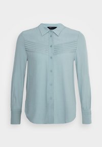 Chemise à manches longues bleu clair en tissu doux. Dotée d'une fermeture boutonnée à l'avant, d'un col et de plis texturés sur la poitrine.