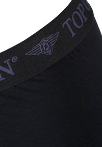 Musta alushousut, joissa on leveä kumihihna, jossa on "TOPON"-teksti ja -logo, suunniteltu mukavuutta varten sileän kankaan rakenteella.