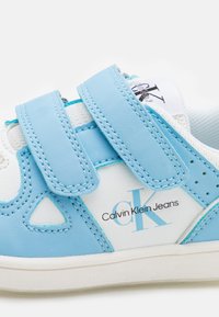 Sneaker sintetiche blu chiaro con accenti bianchi, dotate di cinturini in velcro, perforazioni e logo "Calvin Klein Jeans".