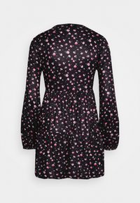 Vestido preto com mangas longas, apresentando um padrão floral em rosa e branco, corpo ajustado e barra com babados. Textura de tecido suave.