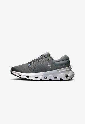 Gray athletic shoe with mesh upper, textured detailing, padded collar, white midsole, and rubber outsole with cutouts for flexibility.
