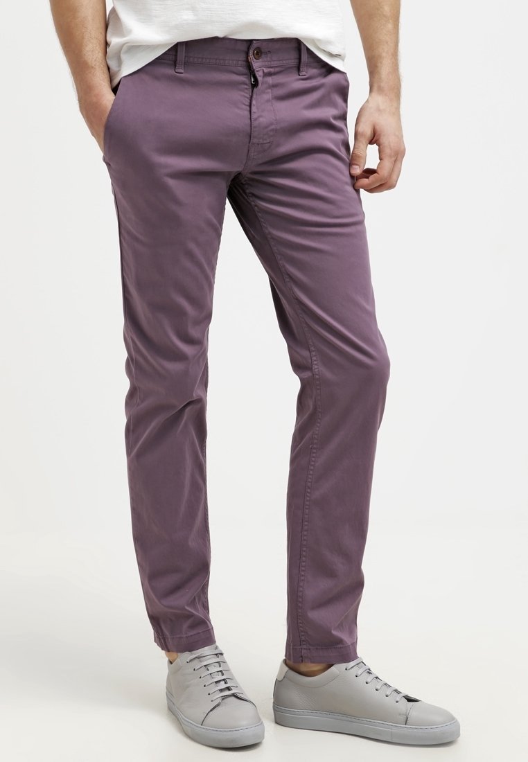 Fioletowe bawełniane chinosy o dopasowanym kroju, z przednimi kieszeniami i zapięciem na guzik. W zestawieniu z szarymi sneakersami. Gładka tekstura.