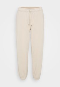 Beige katoenen sweatpants met elastische tailleband, trekkoord en elastische boorden, weergegeven op een eenvoudige witte achtergrond.