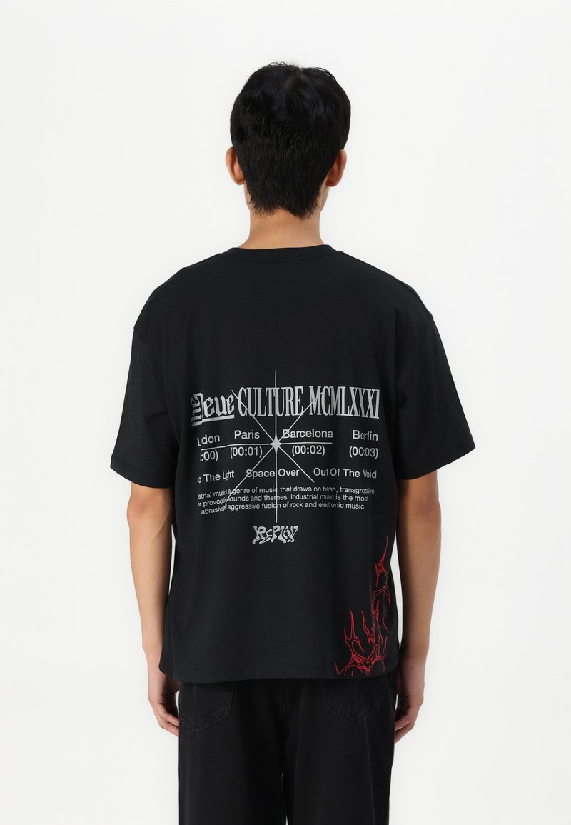 Camiseta de algodón negra con una gran impresión gráfica en la parte posterior, que muestra texto y un diseño de llama roja en la parte inferior. Manga corta, corte relajado.